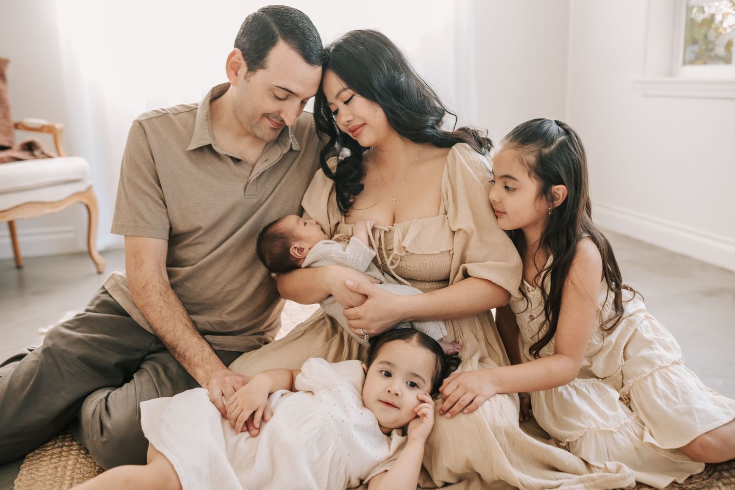 A family relaxes together during an intimate newborn photography session at home.