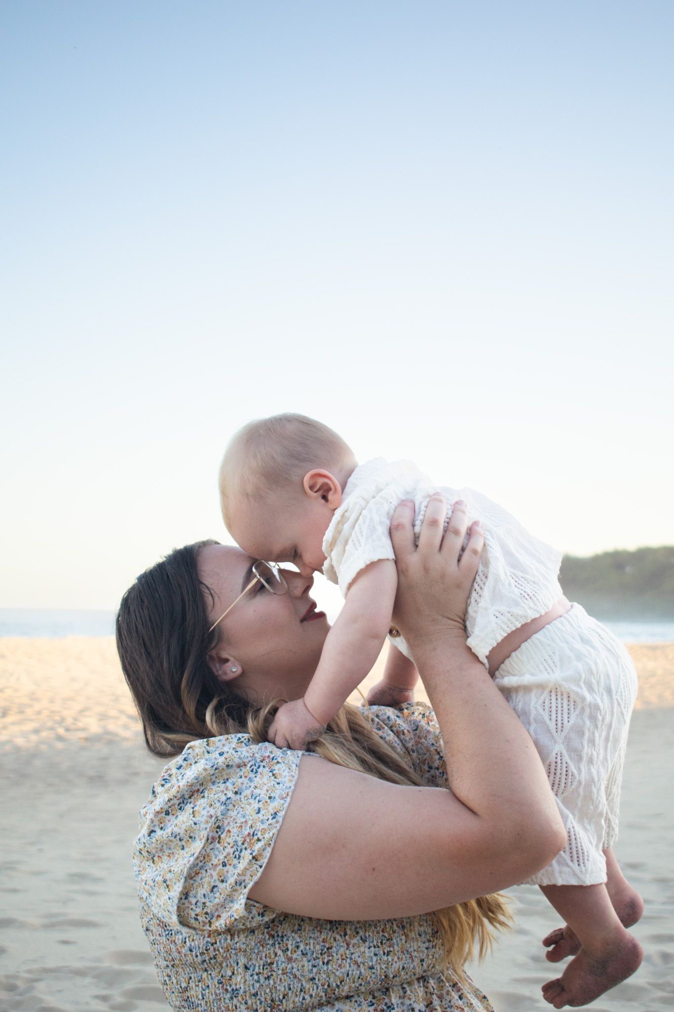 Newcastle motherhood photographer of a mother holding her toddler at the beach
