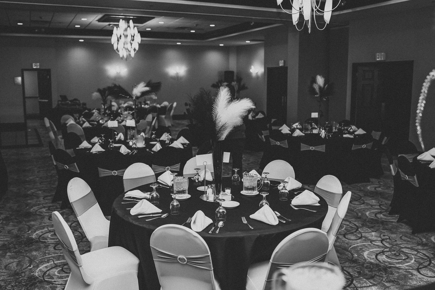 Elegant banquet hall setup with round tables and crystal chandeliers.