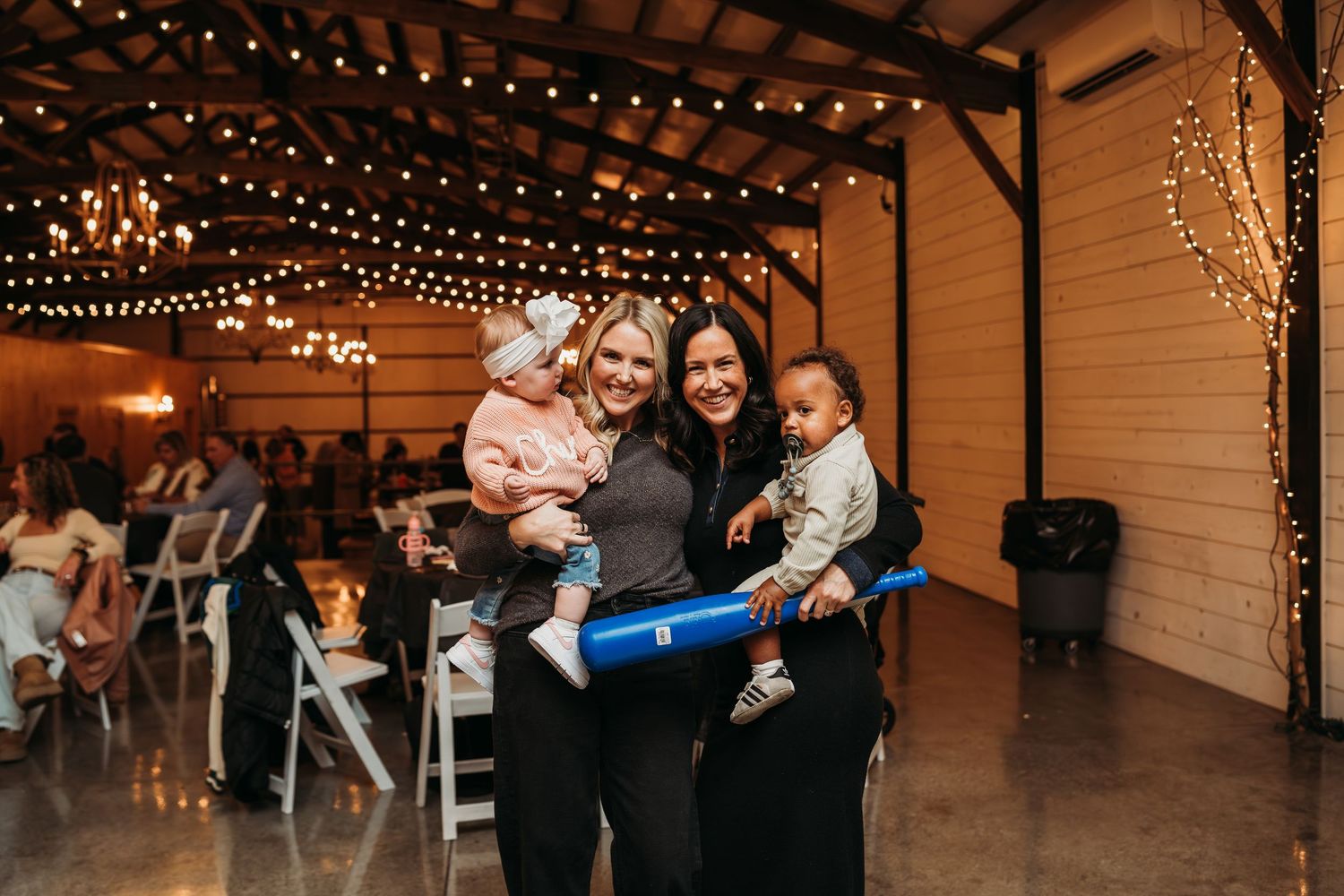 String lights illuminate a rustic indoor venue during an event.