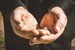 A series of close-up shots showing hands in gentle gestures against a dark background.