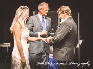 A series of wedding ceremony moments showing couples exchanging rings and embracing on a dark stage with dramatic lighting.