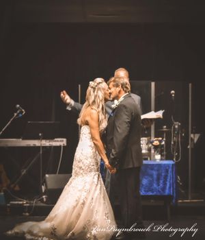 A couple performs a romantic dance sequence on stage during a performance in a dark theater setting.