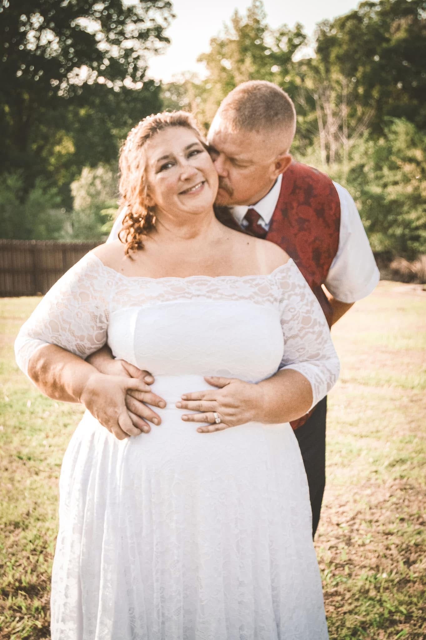A romantic outdoor wedding photoshoot shows tender moments between a couple in white and burgundy attire at sunset.