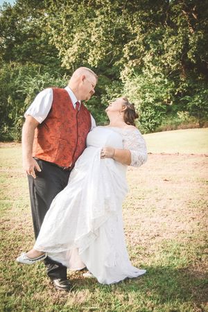 A sequence of romantic photos showing a couple sitting and laying in fallen autumn leaves during a wedding photoshoot.