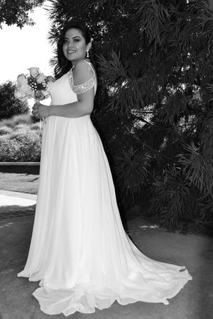 Black and white wedding photos showing flowing white bridal gown details outdoors.