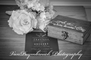 Black and white detail of rustic wooden boxes and white roses arranged for wedding photography.