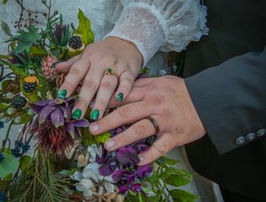Detailed shots of hands holding a colorful wedding bouquet with purple flowers and greenery.