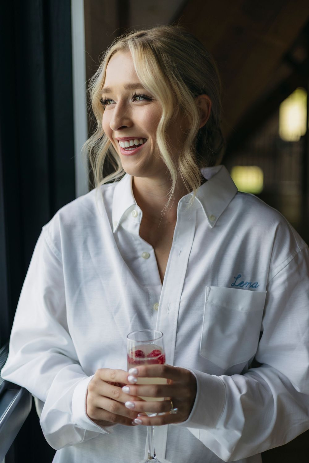 Person in white robe smiling and holding a pink beverage in a series of casual poses.