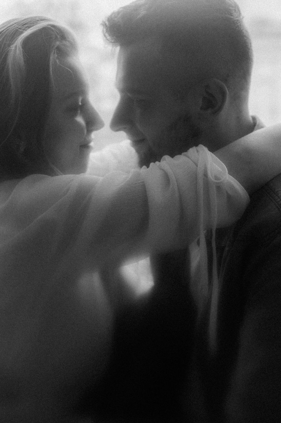 A series of black and white romantic silhouettes showing an intimate couple in soft focus embracing and kissing.