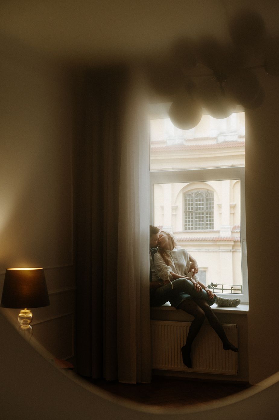 A sequence of images showing a figure sitting by a window in a dark room, creating a moody atmospheric scene.