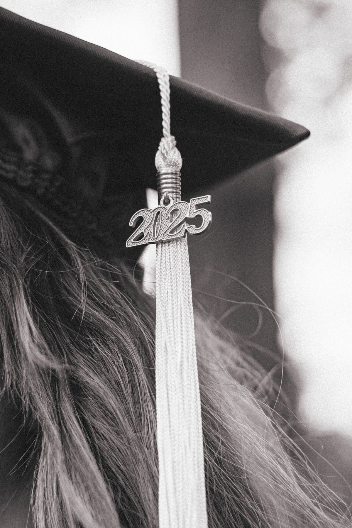 A graduation tassel with 2025 charm shown in black and white close-up.