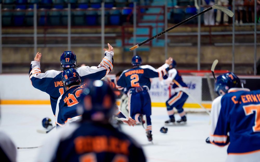 Trojans hockey players skate toward their goalie in celebration after the championship win by SportsFox Photography, Hershey PA.