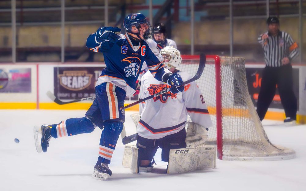 Trojans player celebrates after a goal—one congratulates the scorer for the assist by SportsFox Photography, Hershey PA.