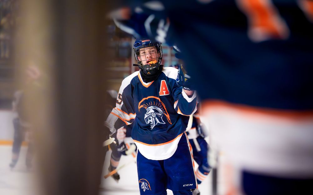 Trojans player smiles and skates toward the bench after a big play in the championship by SportsFox Photography, Hershey PA.