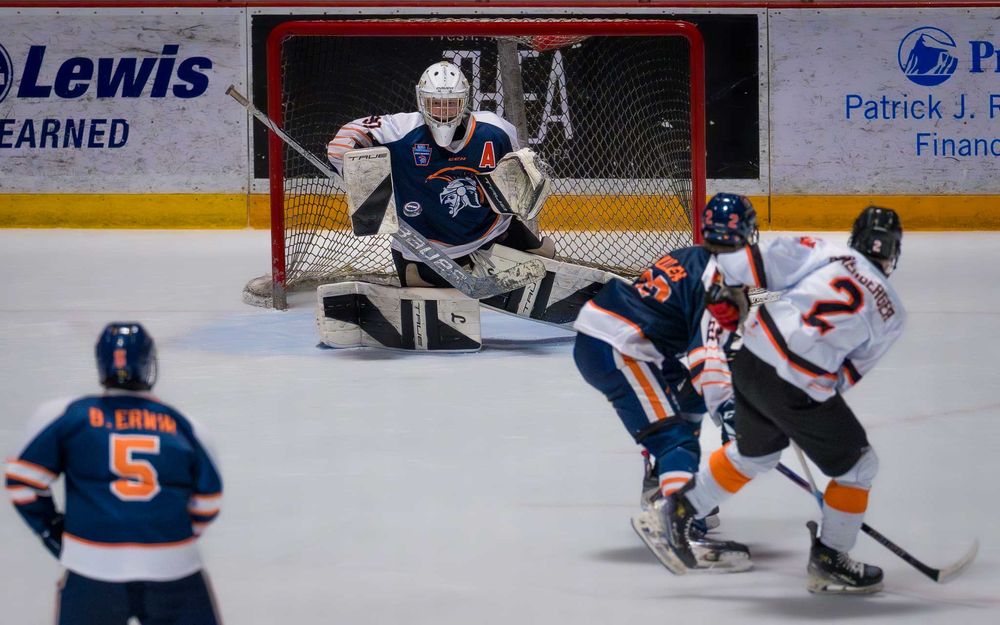 Trojans goalie makes a crucial save as teammates and opponents look on by SportsFox Photography, Hershey PA.