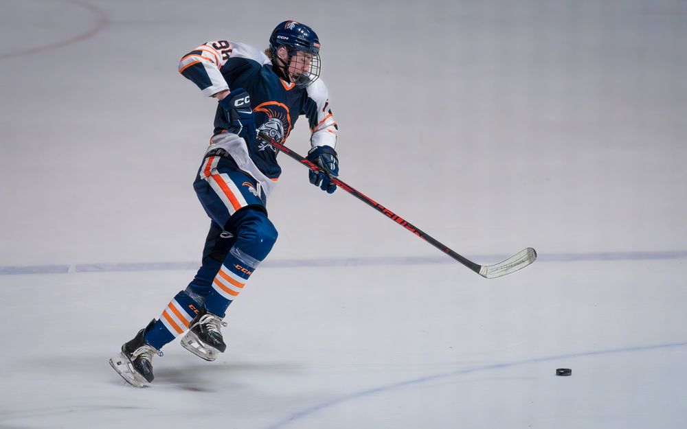 Trojans player skates up the ice with the puck during the Bears Cup Championship by SportsFox Photography, Hershey PA.