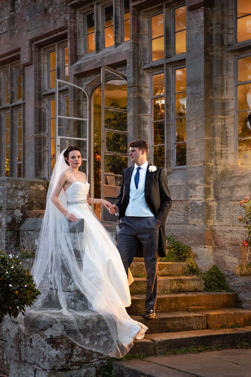 Bride and groom on steps of Wadhurst Castle