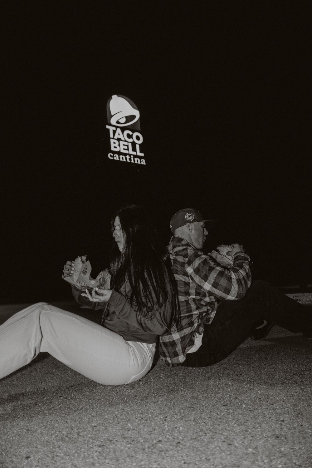 A sequence of black and white photos showing someone lying on the ground at night near a Taco Bell sign.