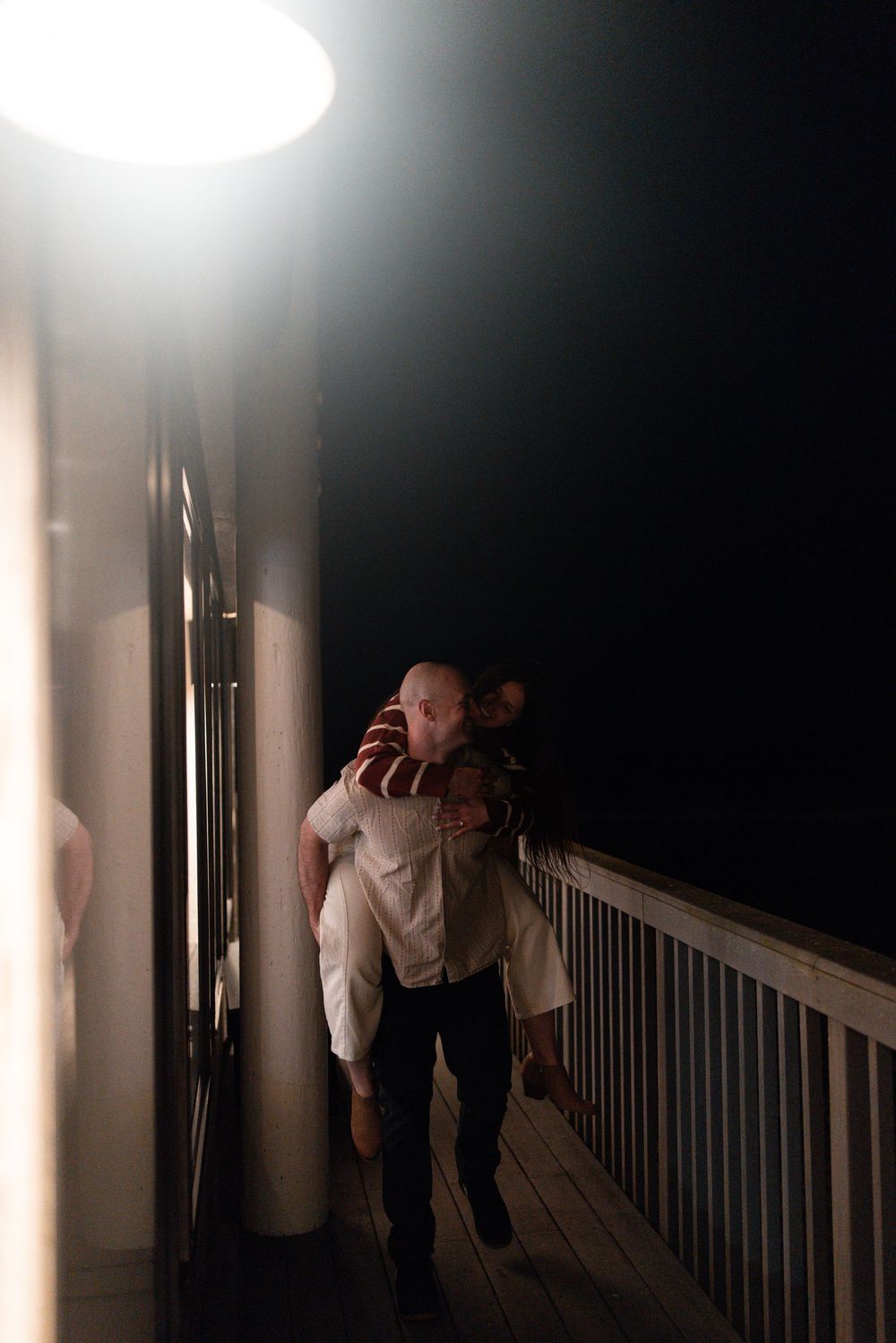 A series of dark atmospheric shots showing someone leaning over a railing in a dimly lit hallway at night.
