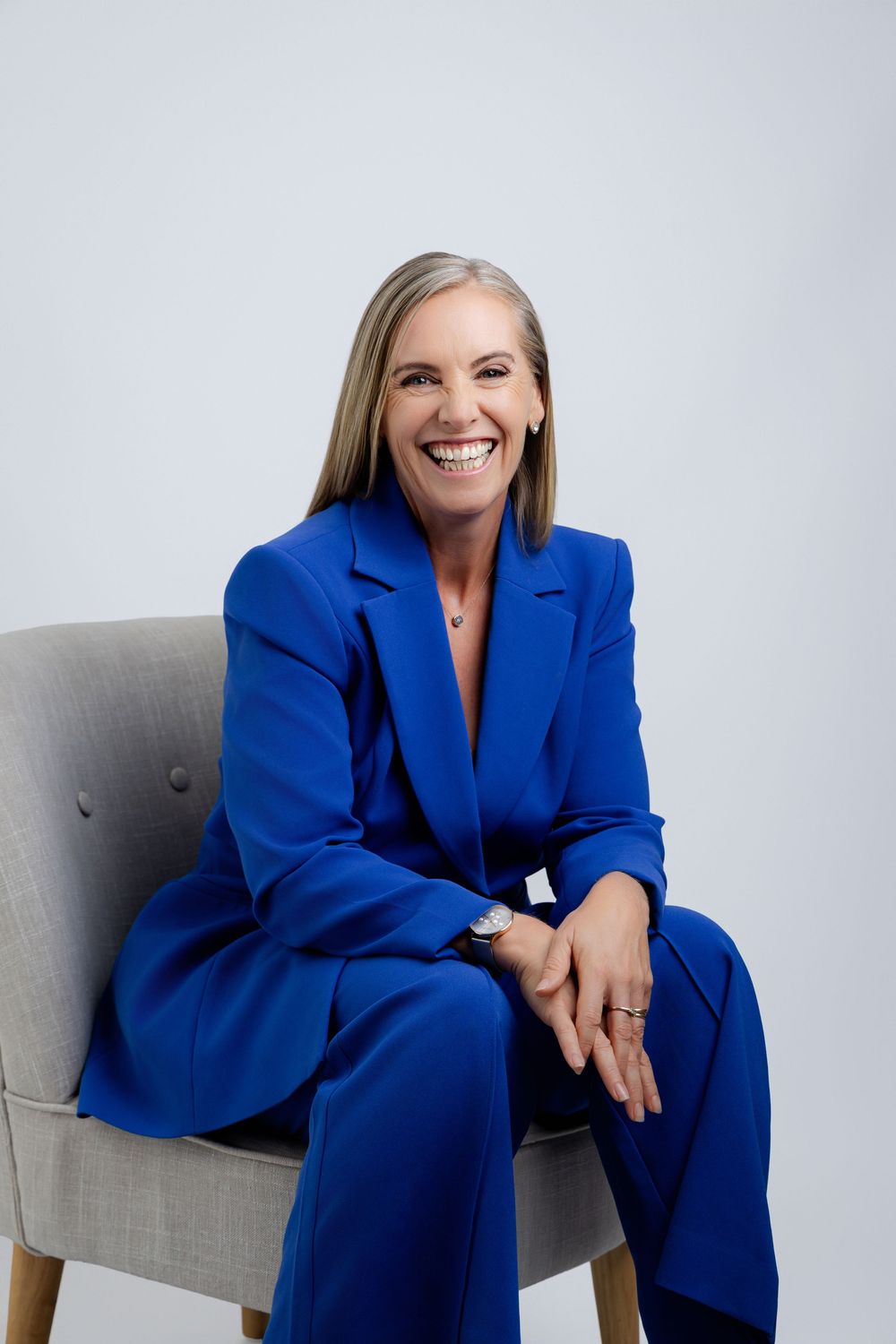 Professional branding photoshoot showing businesswoman in a vibrant royal blue suit smiling