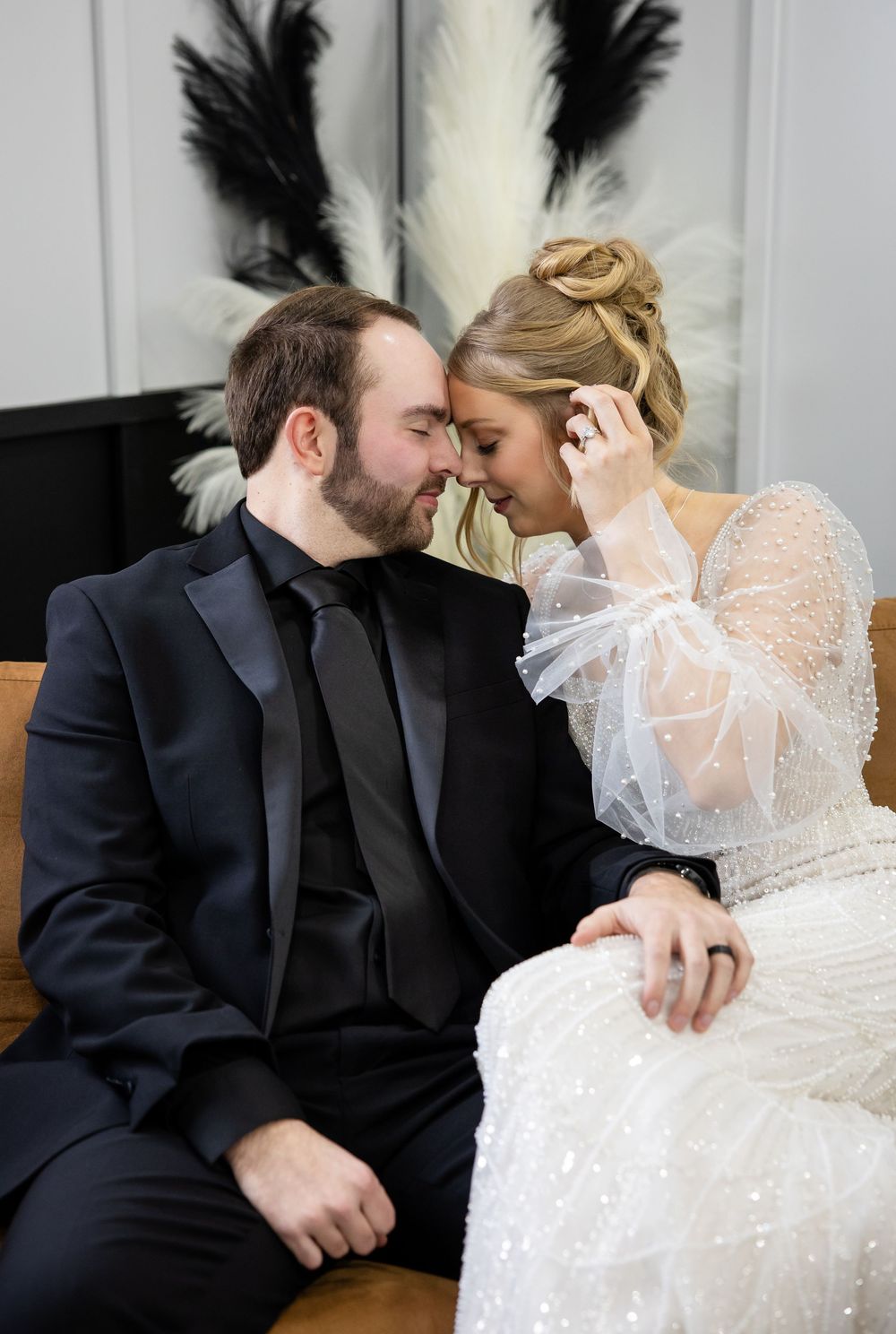 A romantic series of wedding photos showing tender moments between a couple on a leather sofa.