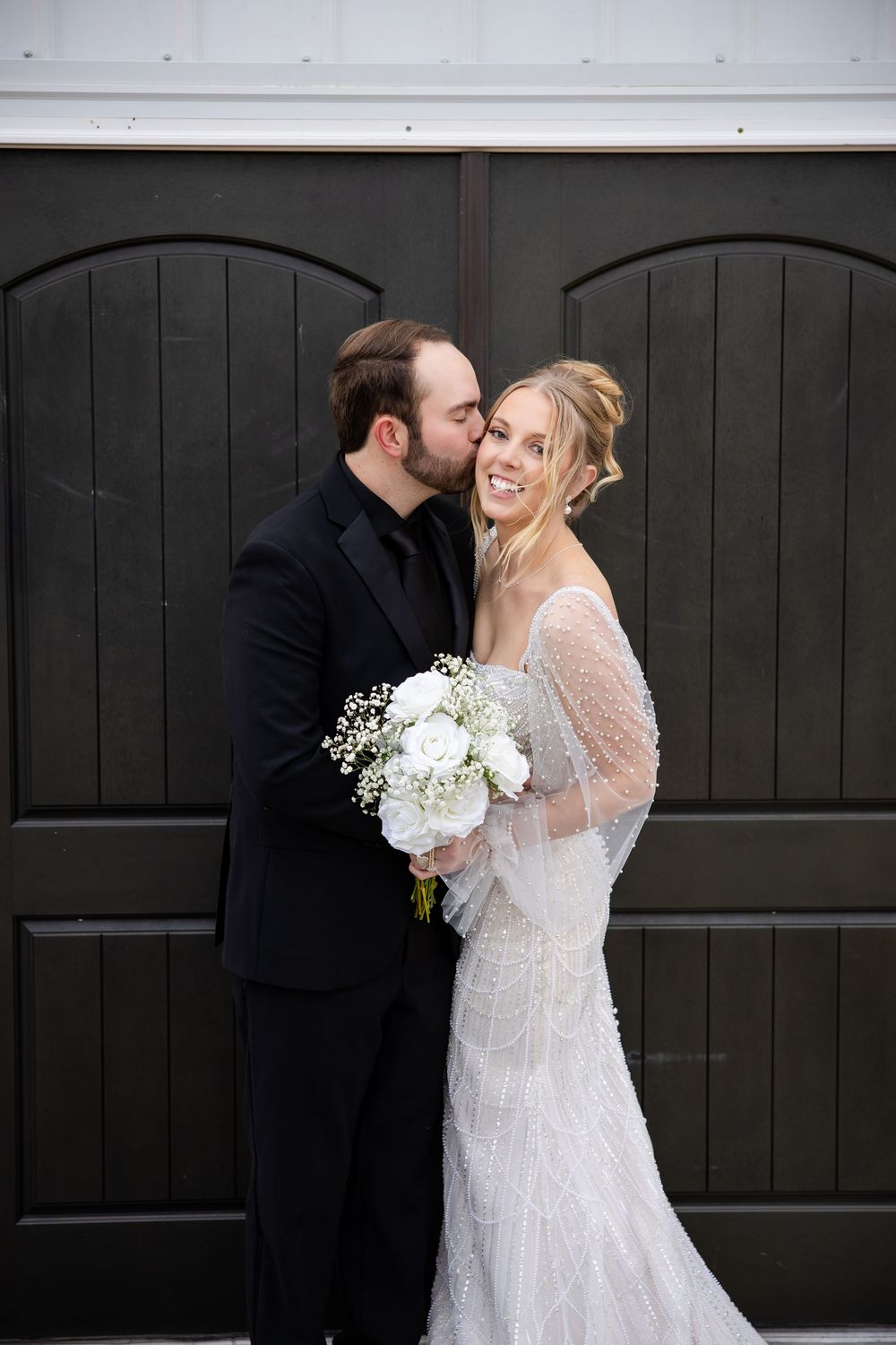 Romantic wedding photos against a black door showing intimate moments between newlyweds.