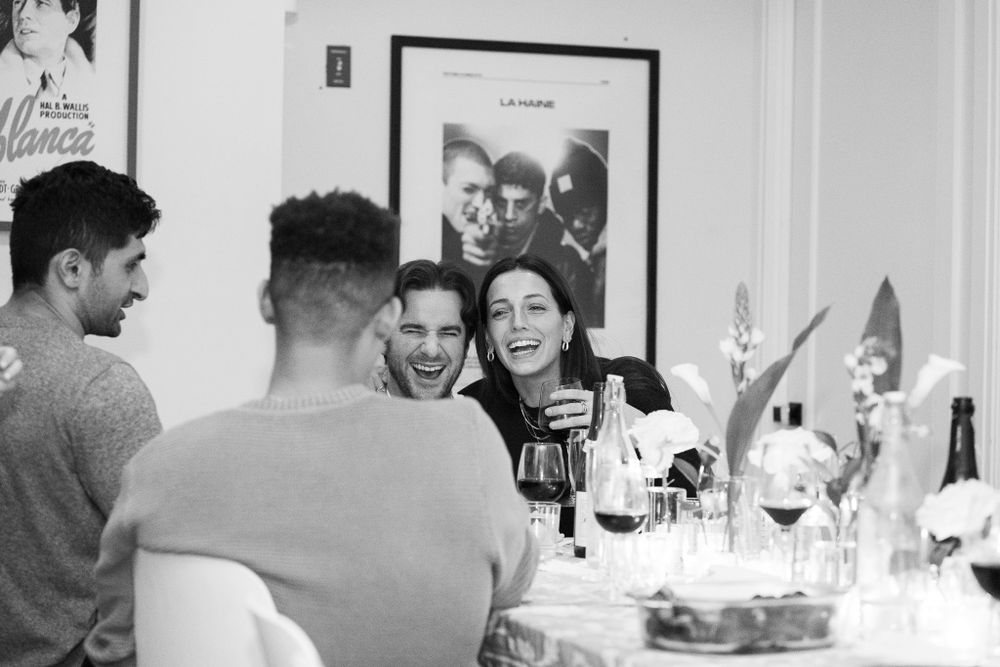 Dinner party guests share laughter and stories around an elegantly set table.