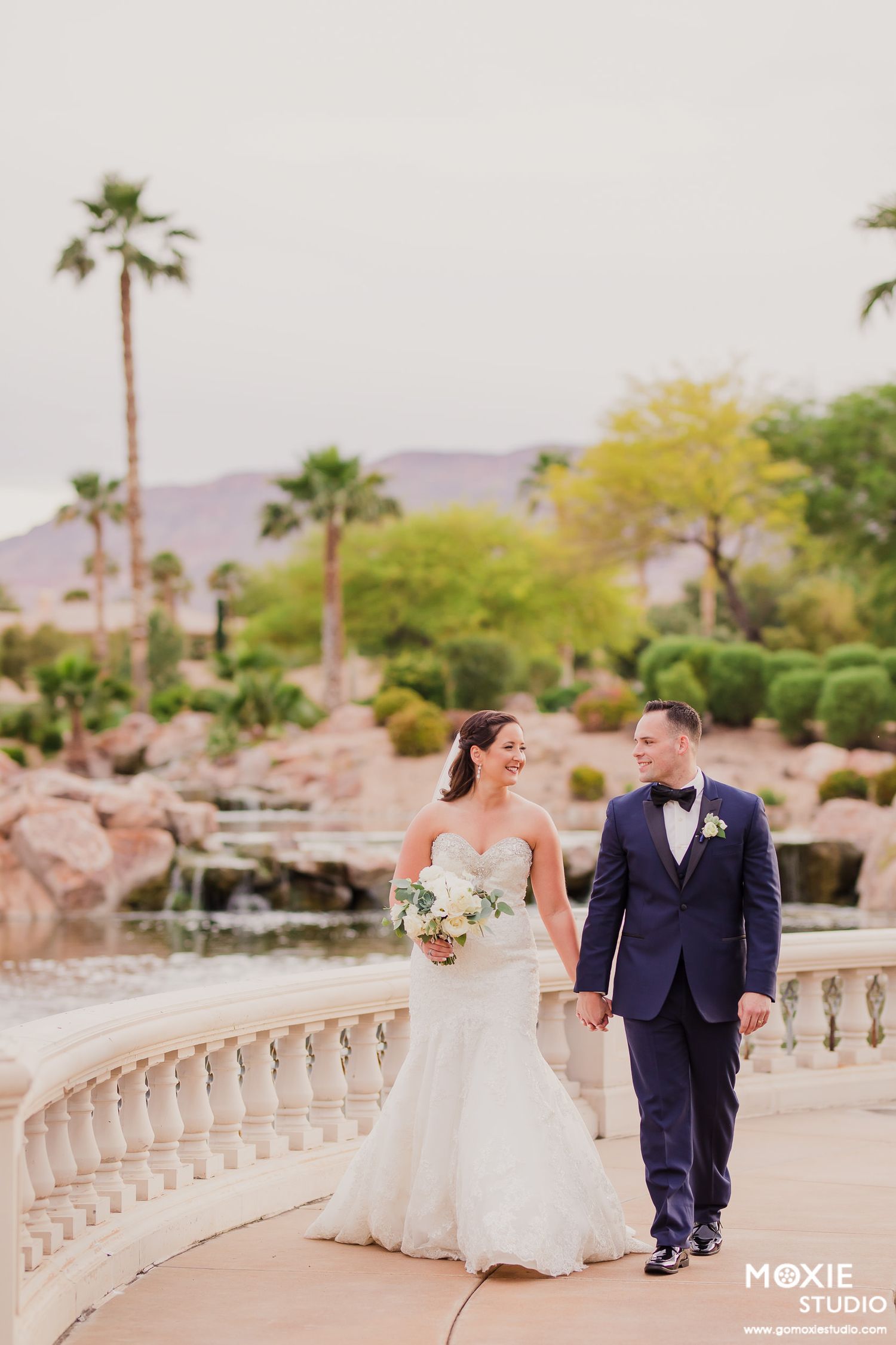 Black and white wedding photos showing a bride in a flowing white dress with a long veil in an elegant hallway setting.