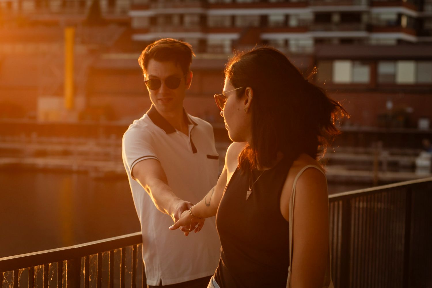 couple walk the waterfront pathway downtown kingston at sunset.