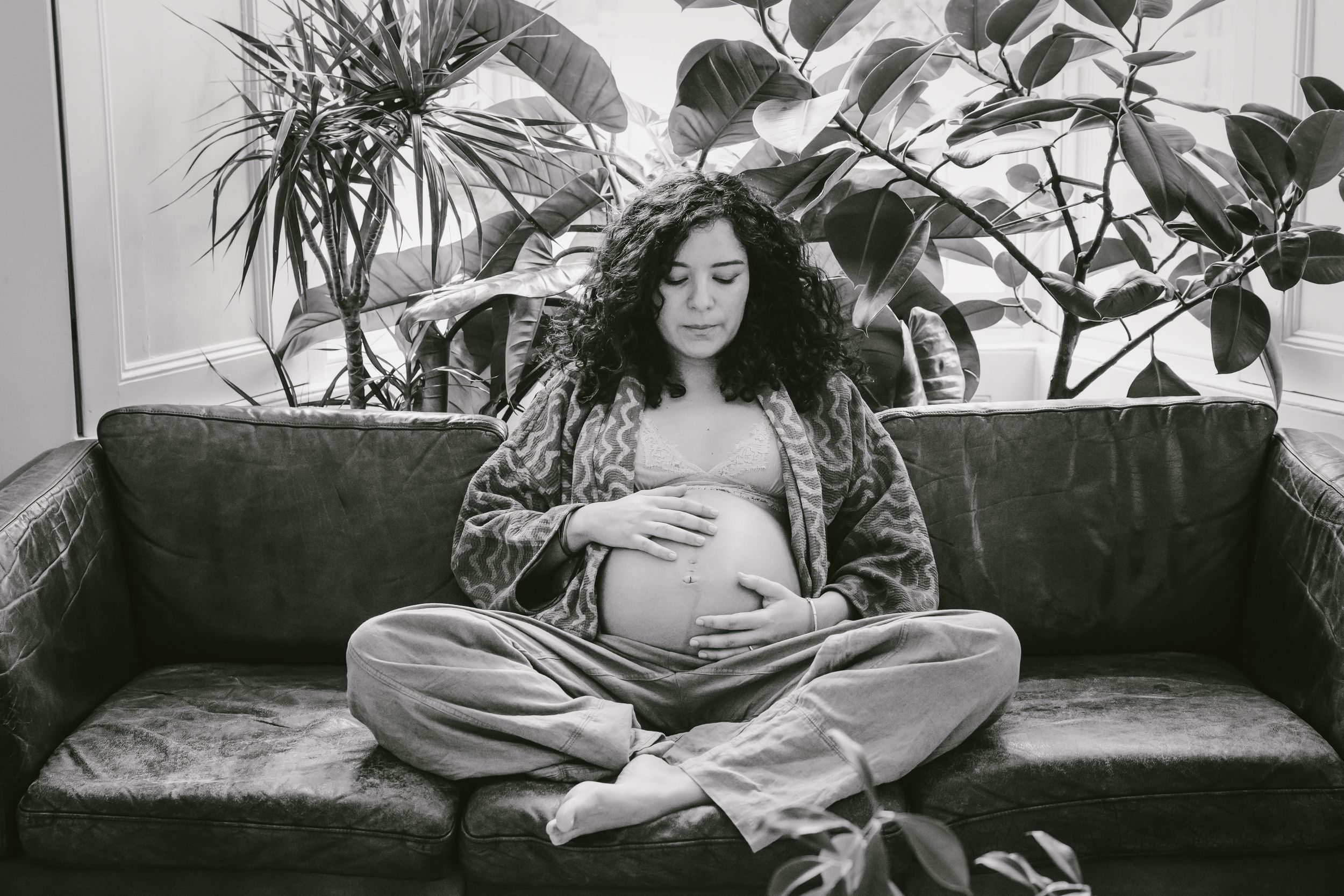 A collection of black and white photos showing a person lounging on a couch surrounded by indoor plants.