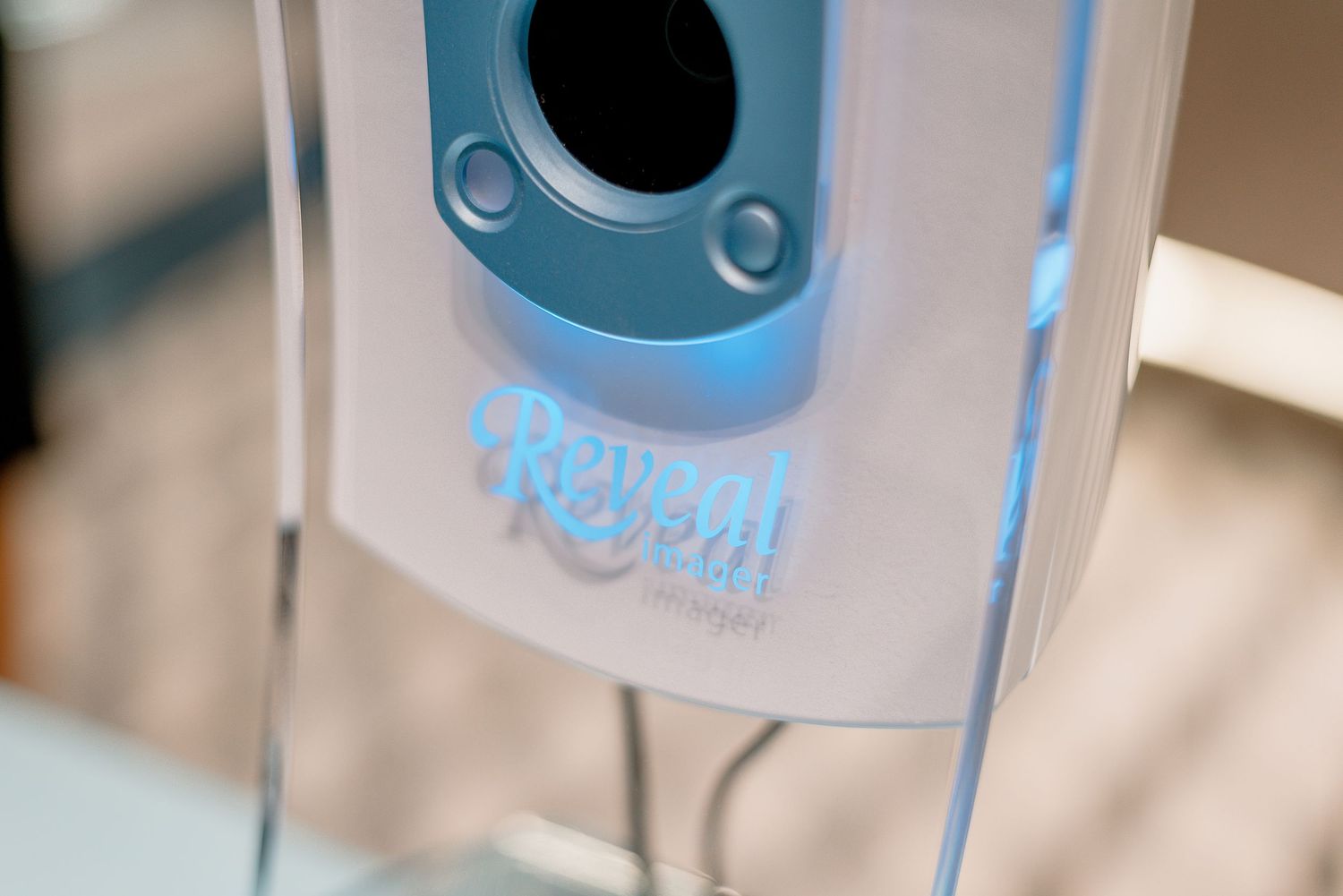 Close-up view of a light blue and white electronic air freshener device mounted on a wall.