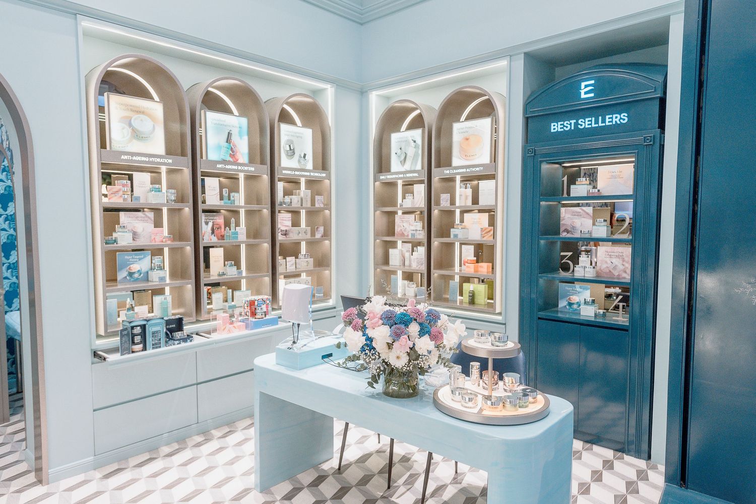 Elegant retail interior with arched display windows and a teal accent wall showcasing beauty products on white shelving.