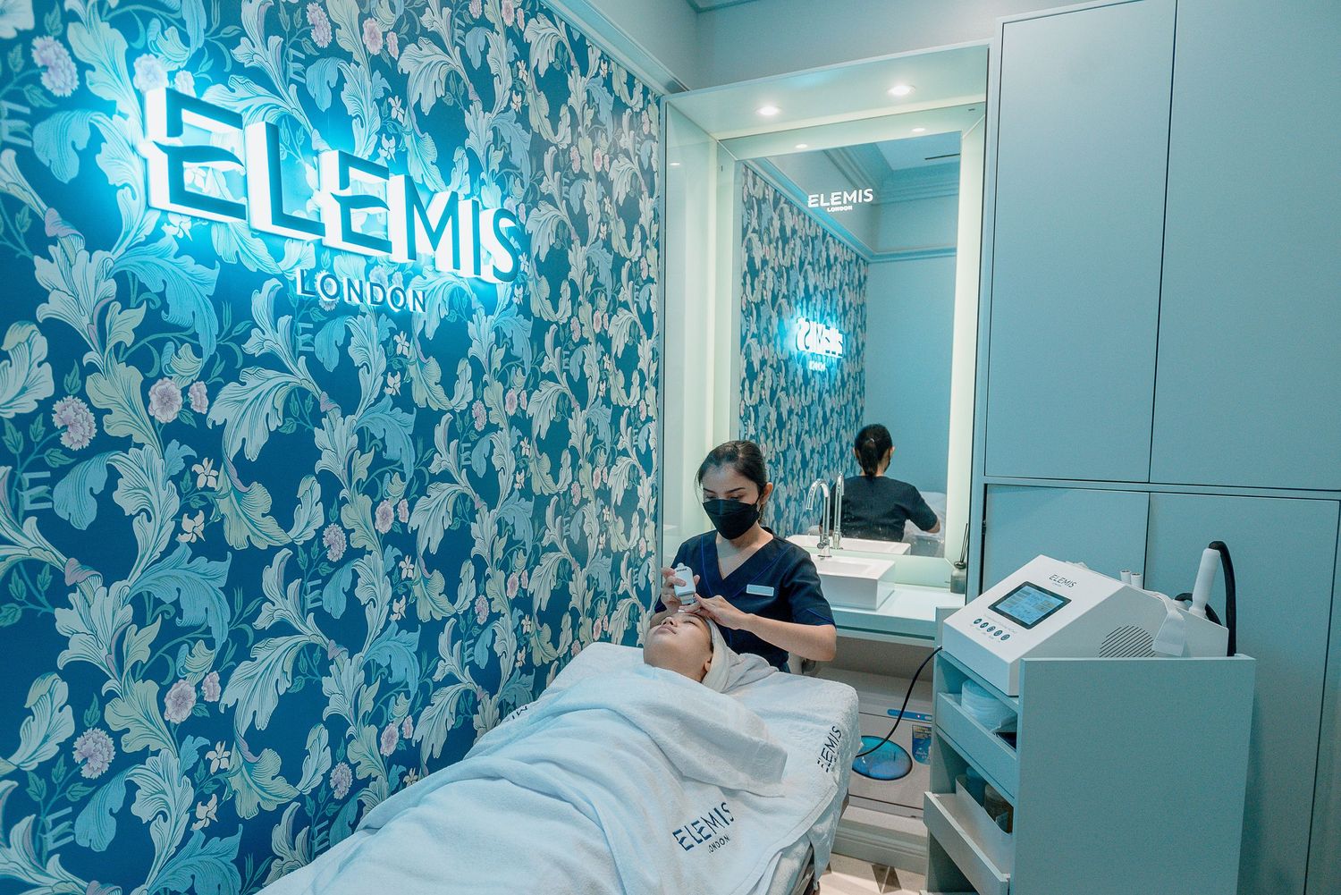 Modern dental office interior with blue floral wallpaper and sleek medical equipment in examination rooms.