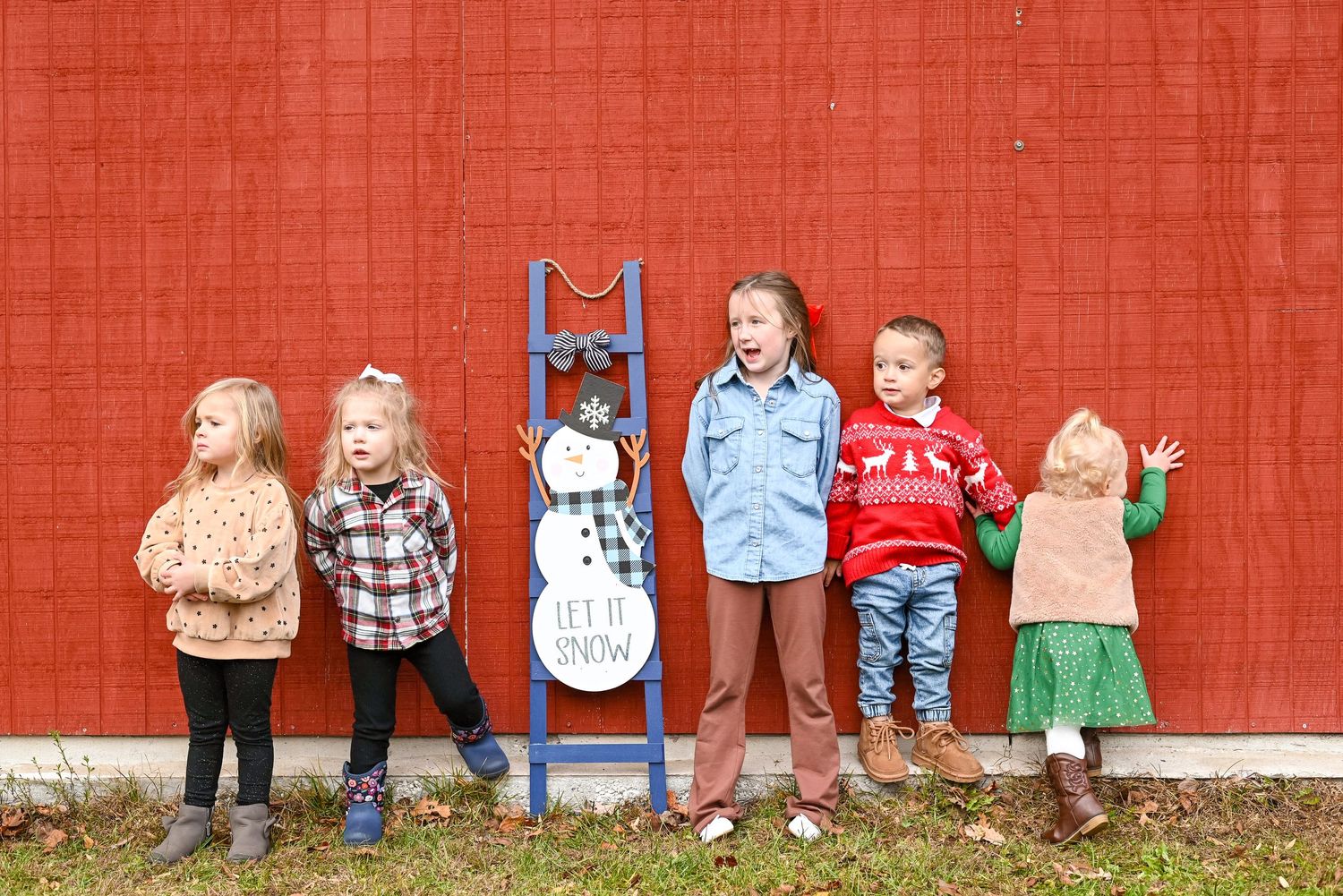A panoramic series of cropped photos showing children's legs and feet lined up against a red wall.