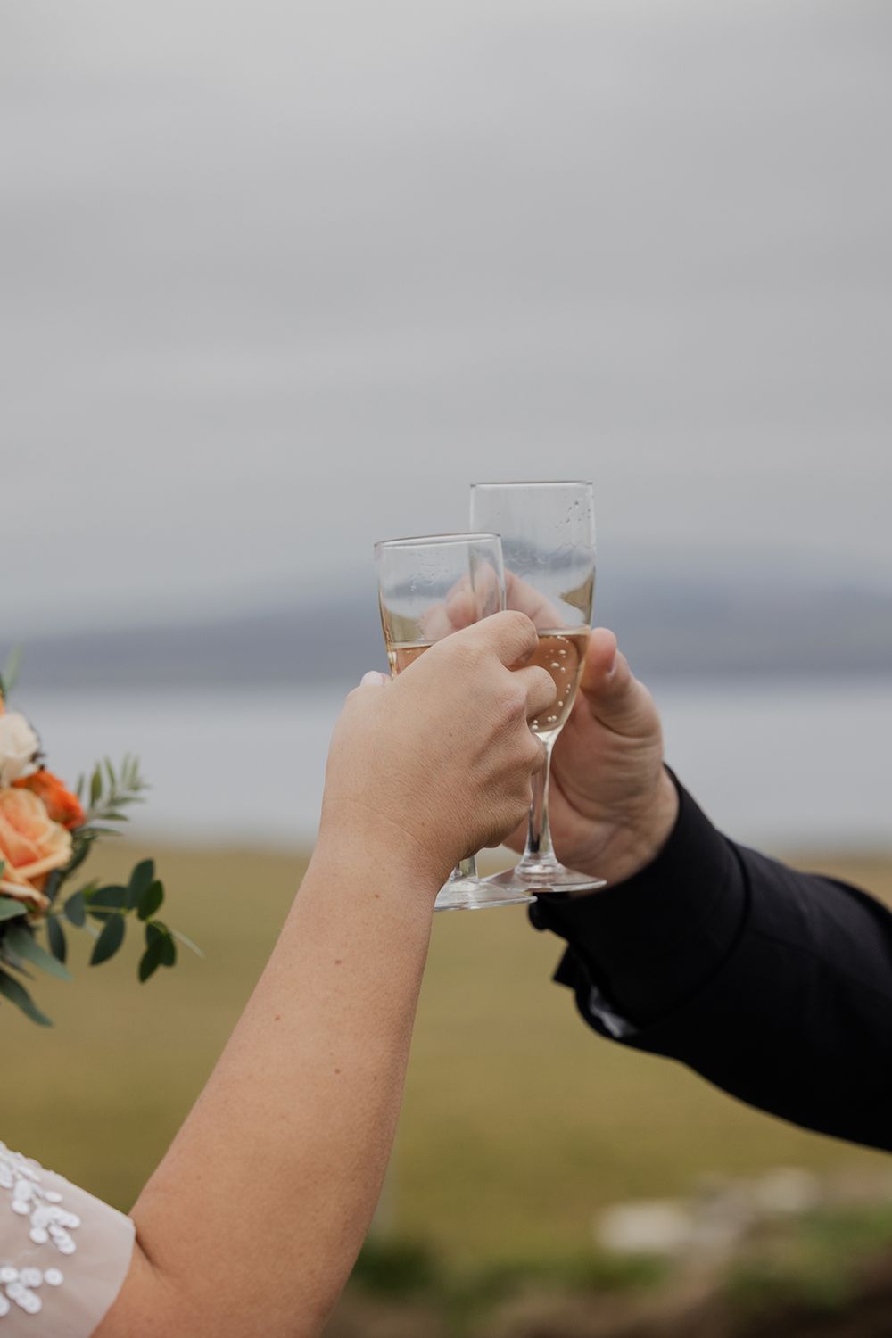 Couple toasting at dramatic Irish coastline during elopement.