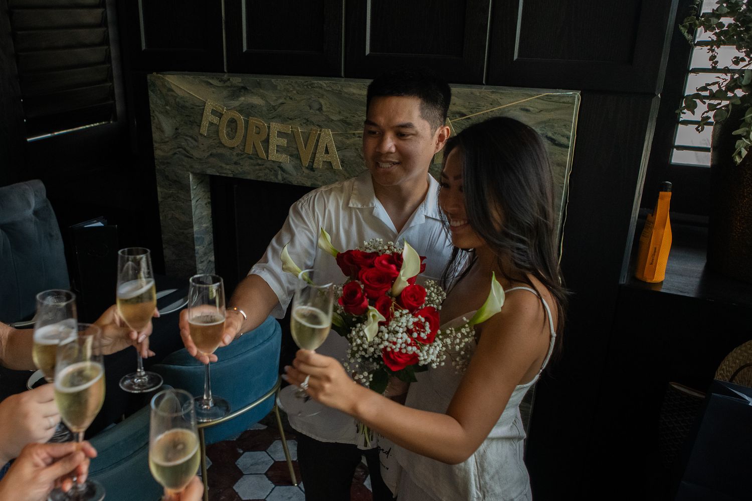 Group toasting with wine glasses during an outdoor celebration with festive decorations.