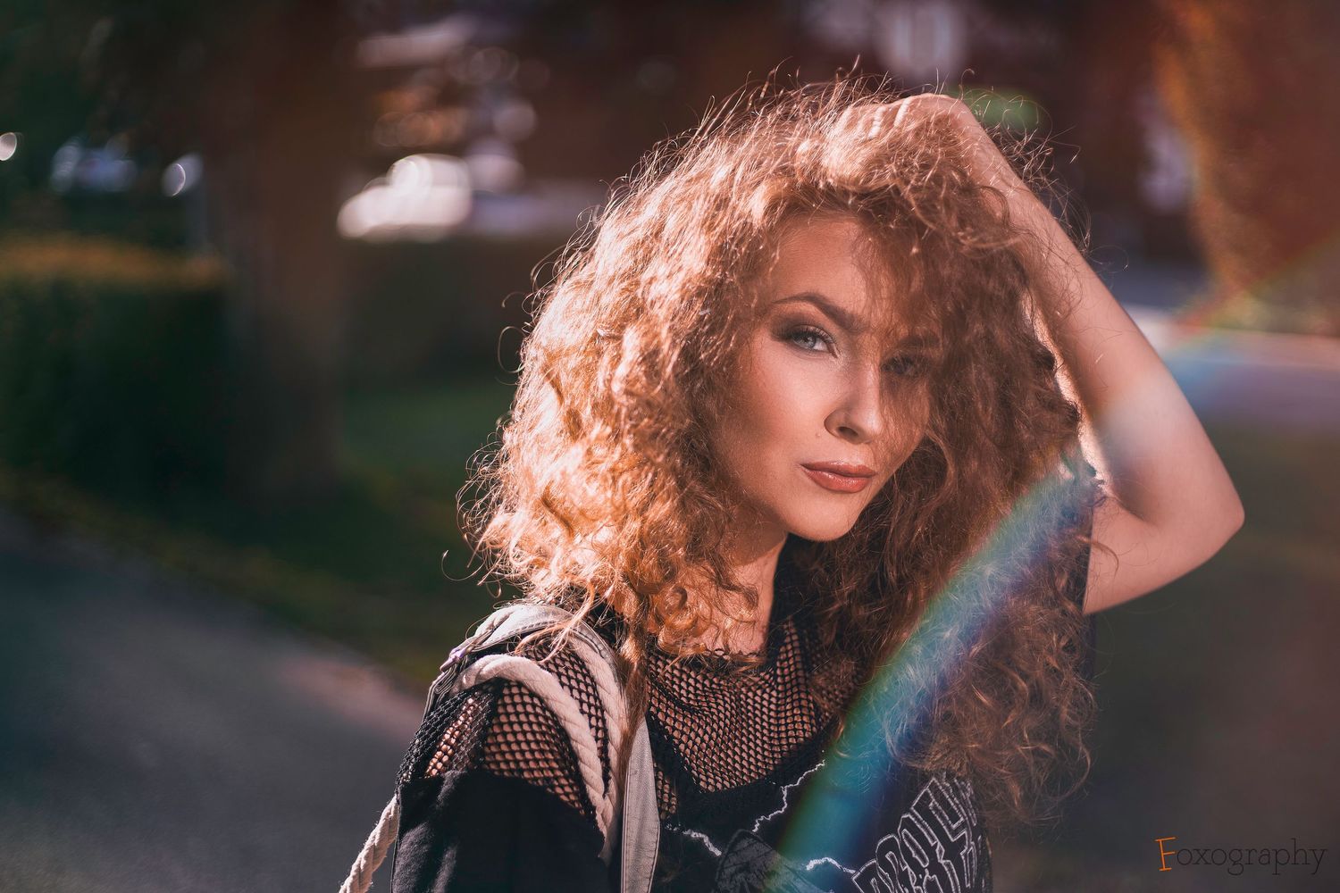 Portrét ryšavej ženy s kučeravými vlasmi pózujúcej vonku s farebnými svetelnými bokeh efektmi. Umelecká fotografia, Rajecké Teplice.