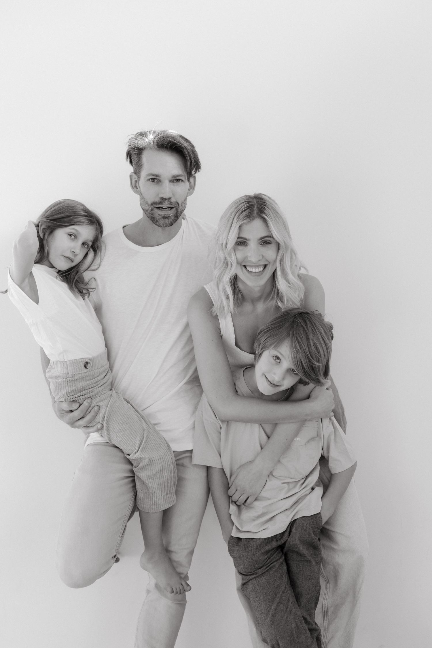 A series of black and white family portraits showing playful poses and interactions against a white background.