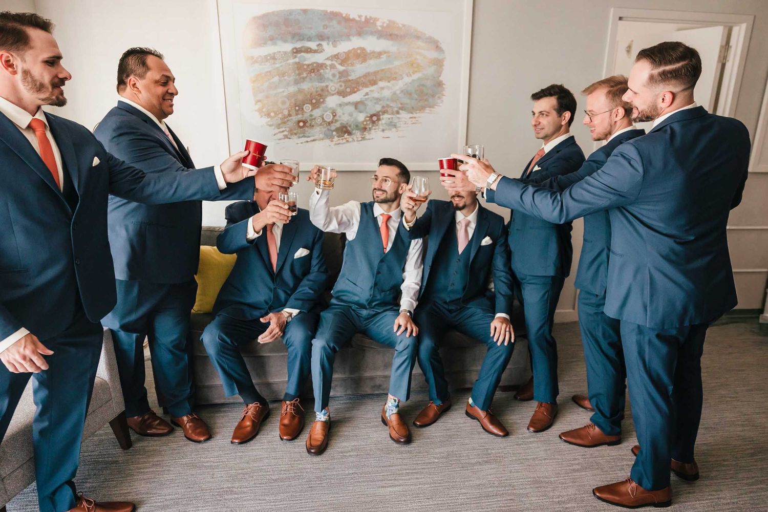 Groom and groomsmen raising glasses for a toast during Boston wedding preparations