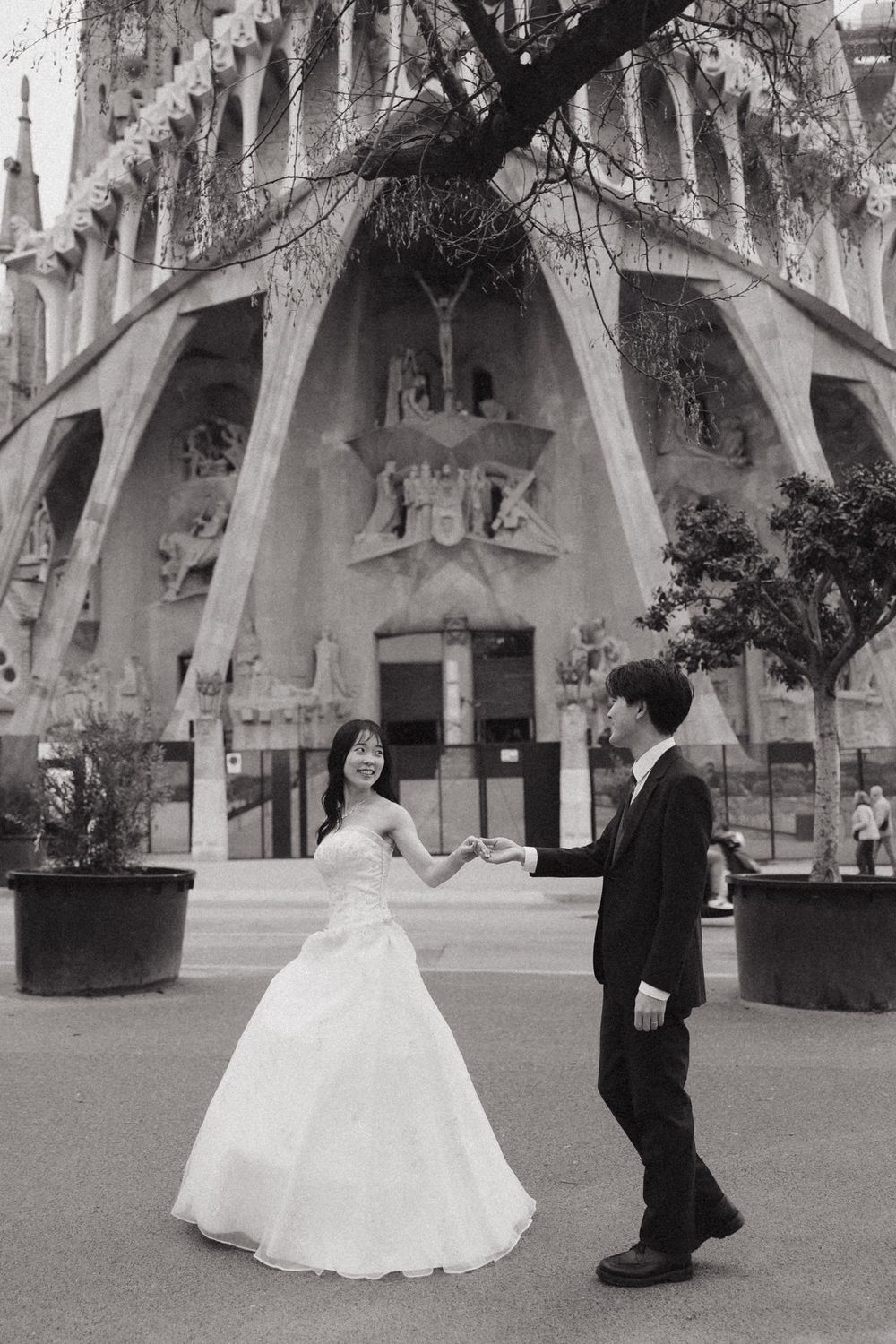 A sequence of black and white wedding photos showing a couple dancing together in a grand architectural space. Couple Photoshoot Barcelona
