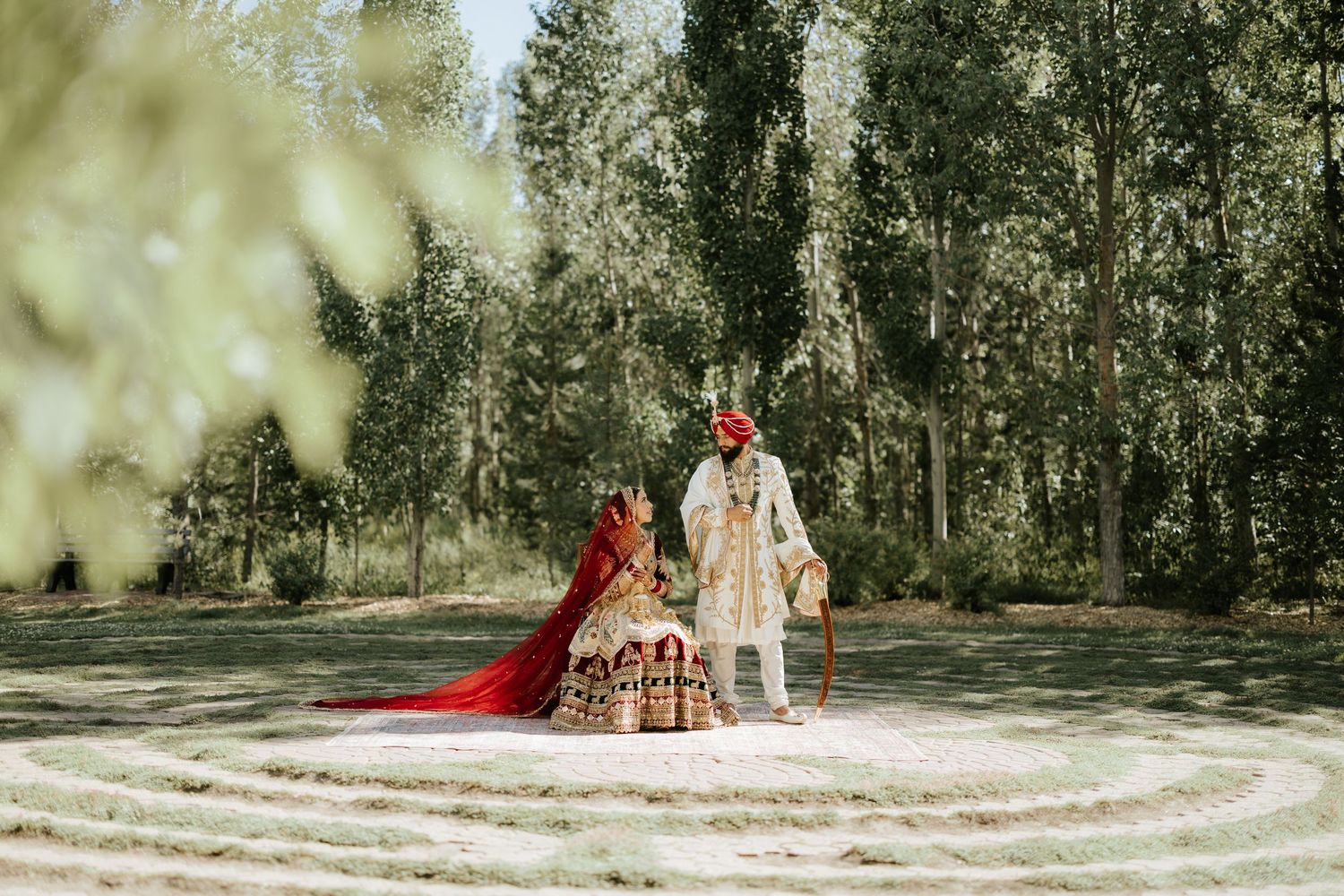 Wedding ceremony setup with white drapes and couple in traditional Indian attire.