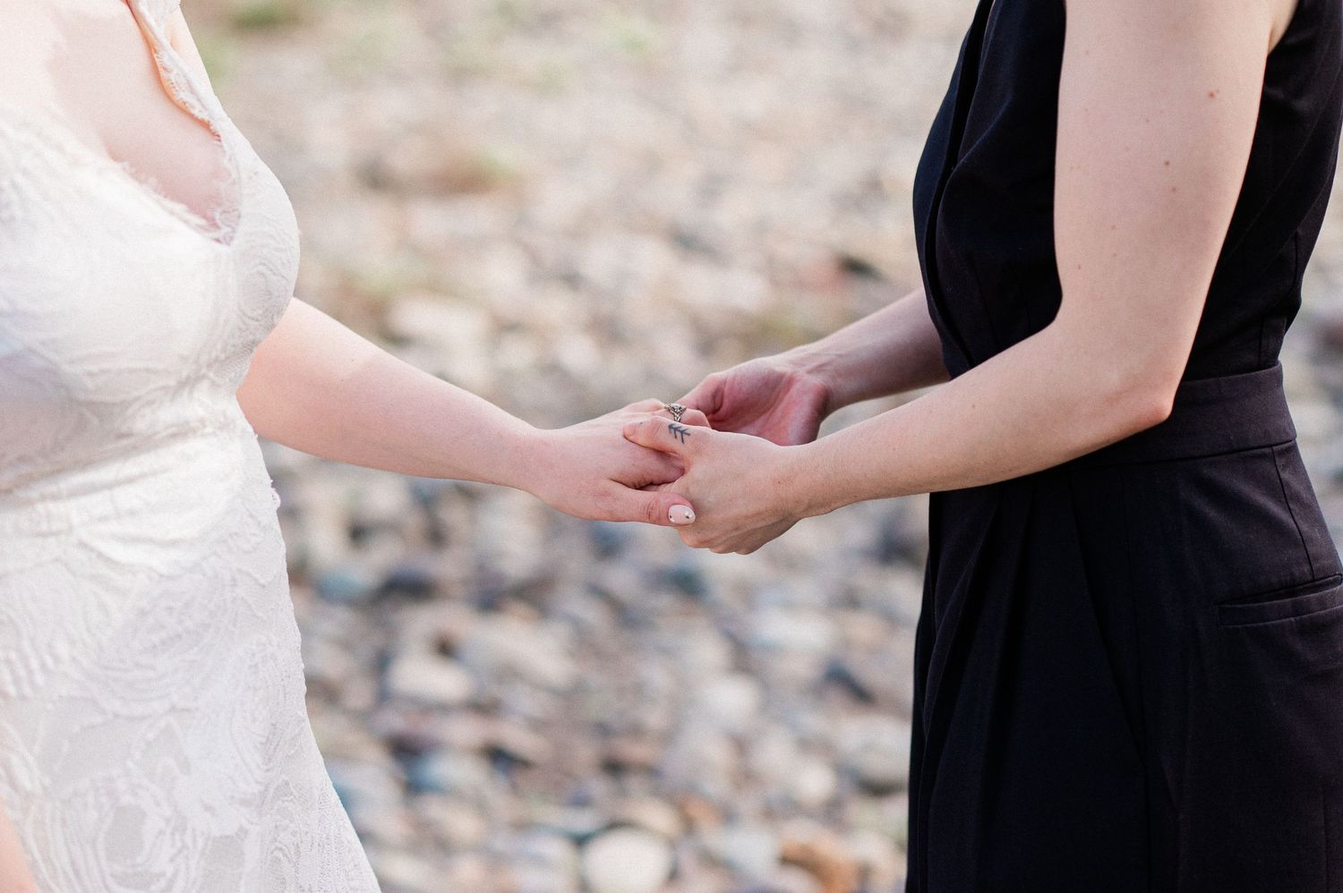 Close up of ring exchange during elopement ceremony on a rocky shoreline.