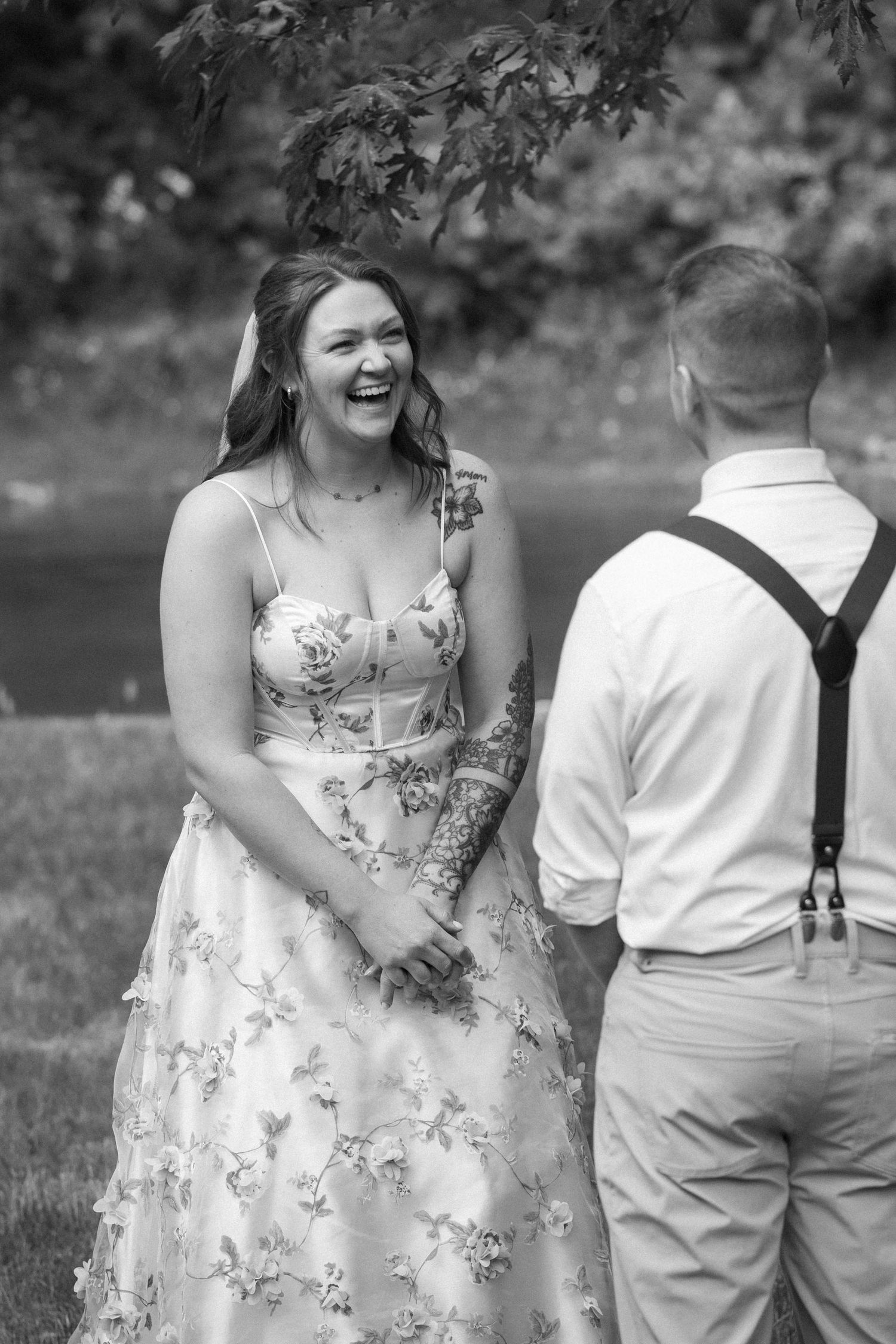 A couple shares candid moments outdoors in a series of black and white photos showing joyful interactions.