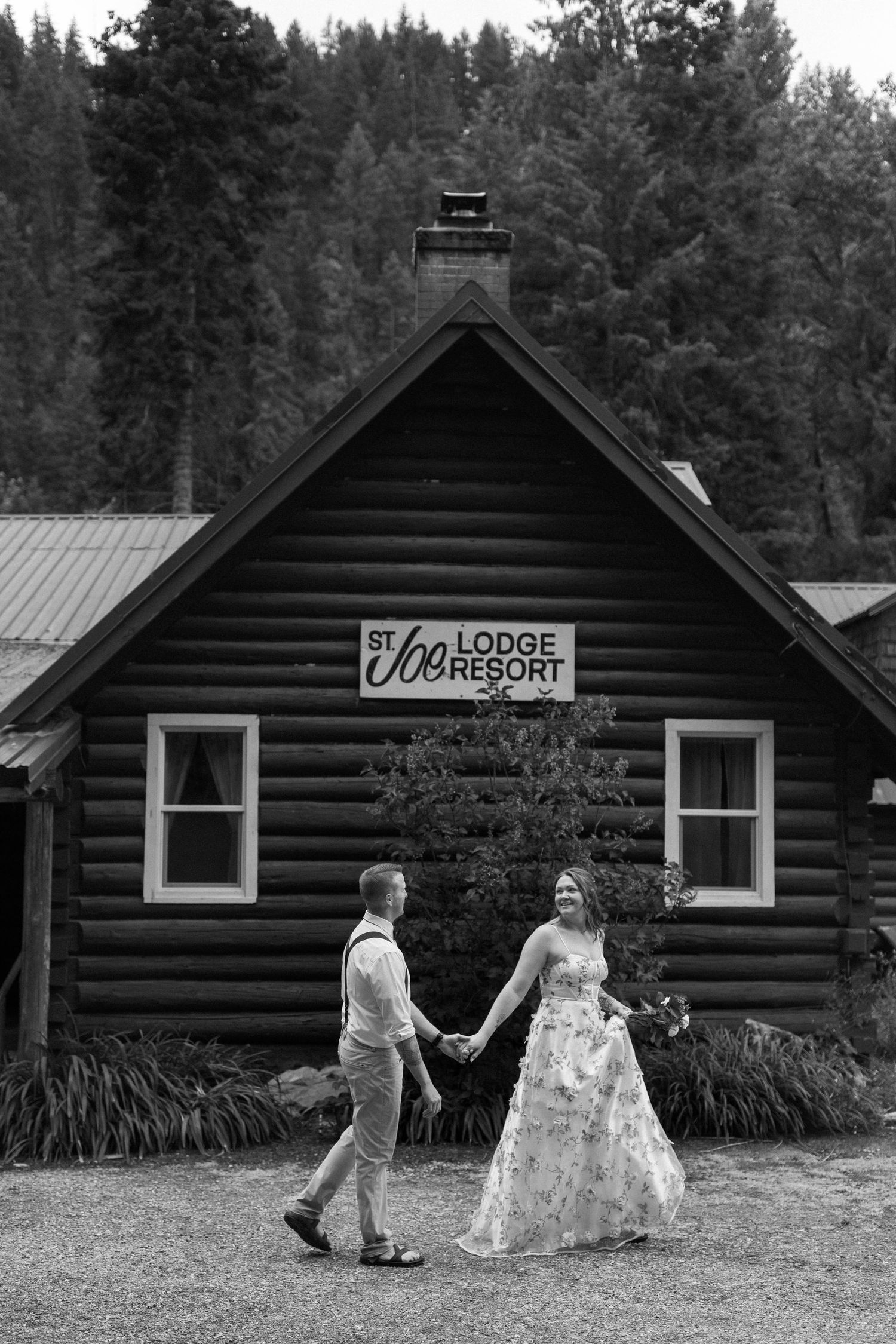 A black and white photo series showing a couple walking past rustic log cabin lodges in a wooded setting.