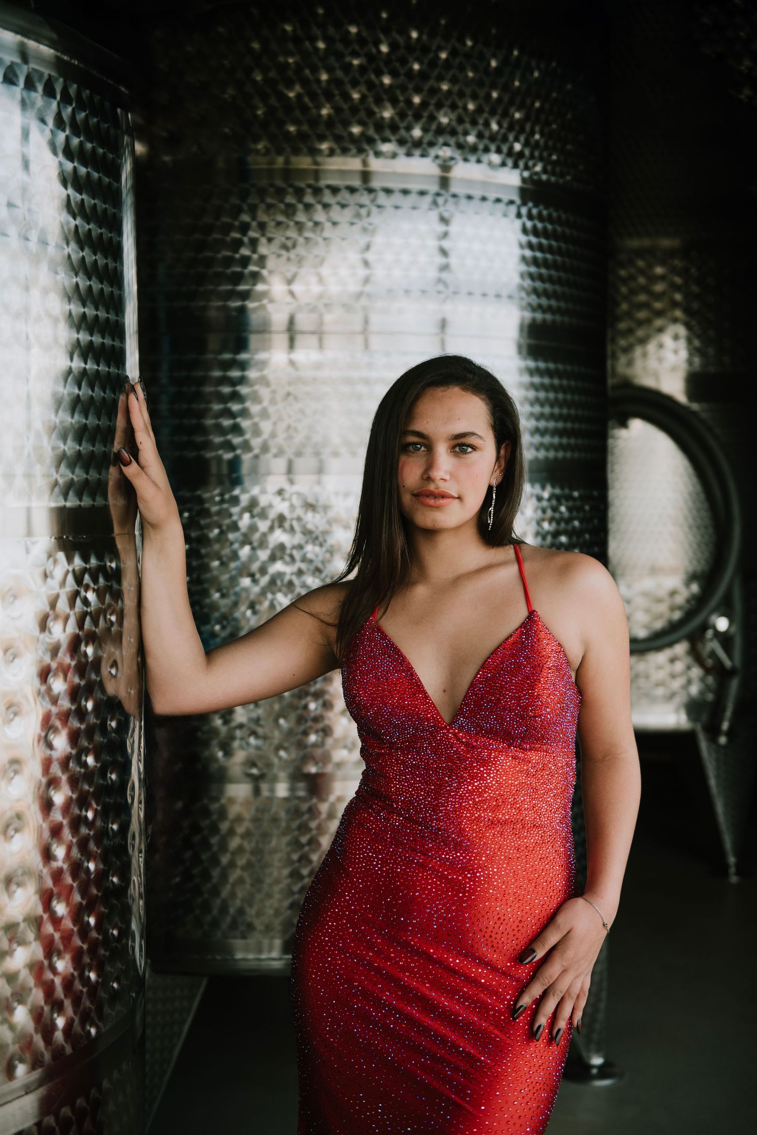 Girl in a red dress posing at Beleia Wines vineyard, elegant setting with scenic wine estate backdrop