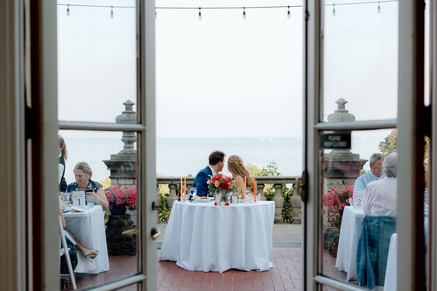 Villa Terrace wedding couple shares romantic moment overlooking Milwaukee lakefront view captured by Ashton Gonnering Photography