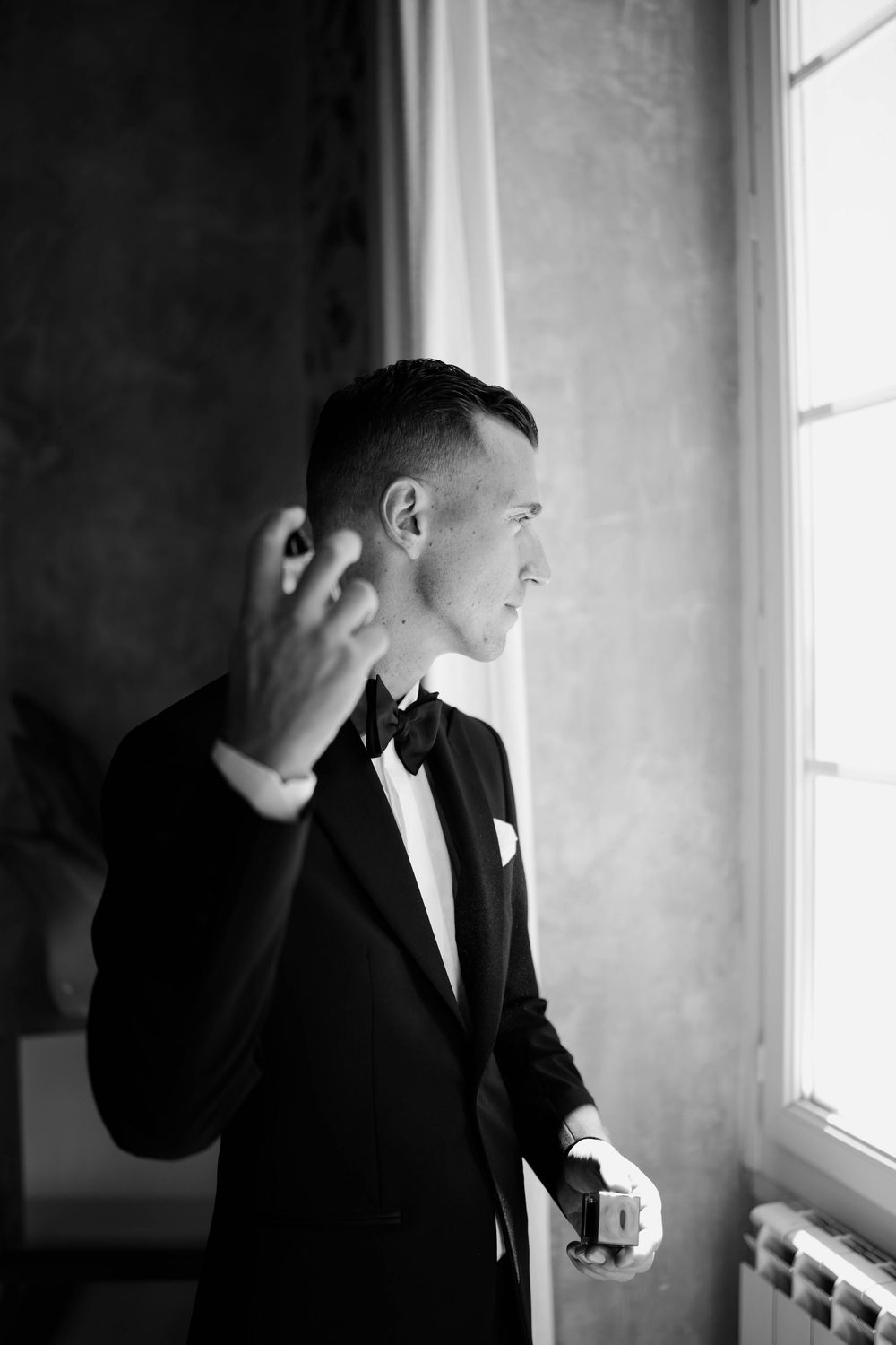 Le marié se mettant du parfum, photo en noir et blanc super belle
