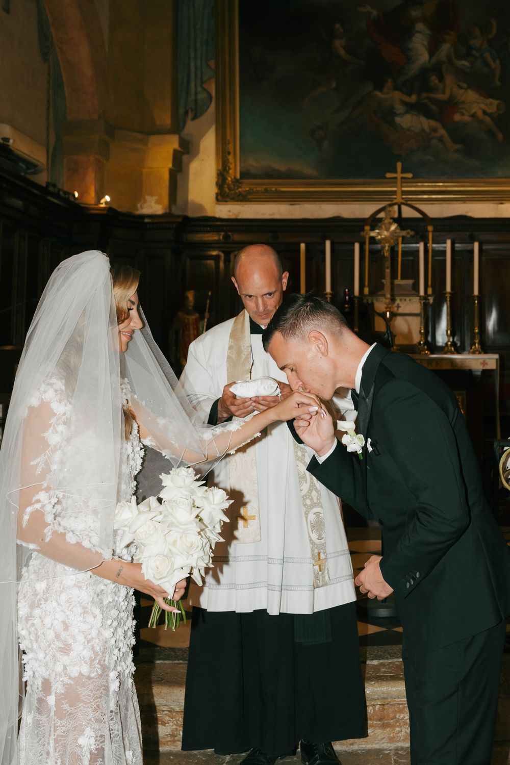 Cérémonie de mariage catholique traditionnelle qui a lieu dans une église avec un prêtre officiant à l'autel.