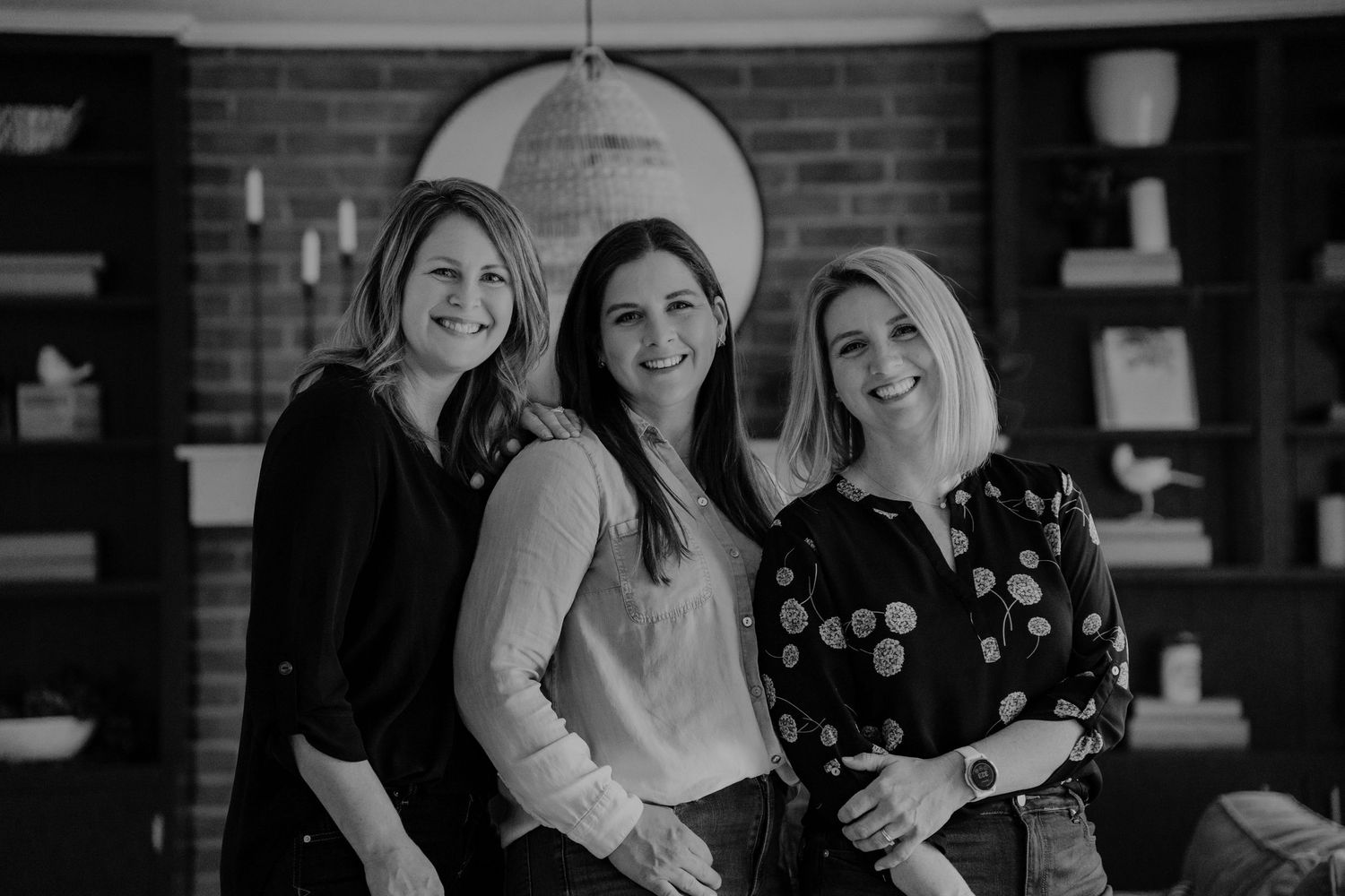 Three colleagues stand together smiling in an in-home brand photo session in Hudson, Ohio.